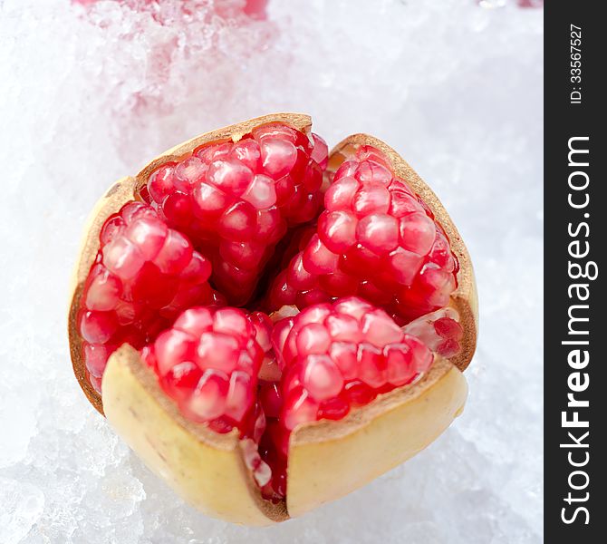 Red pomegranate fruit on ice