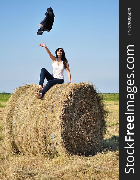 Beautiful girl sit on haystacks