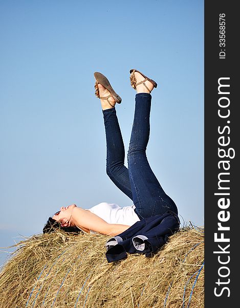 Beautiful girl sit on haystacks