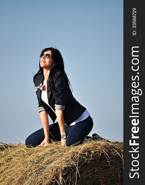 Beautiful girl sit on haystacks