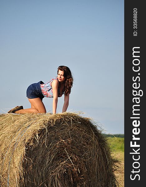 Beautiful girl sit on haystacks