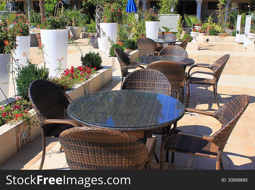 Modern outdoors bar area on the wooden deck of a resort patio surrounded by decorative flowers. Modern outdoors bar area on the wooden deck of a resort patio surrounded by decorative flowers