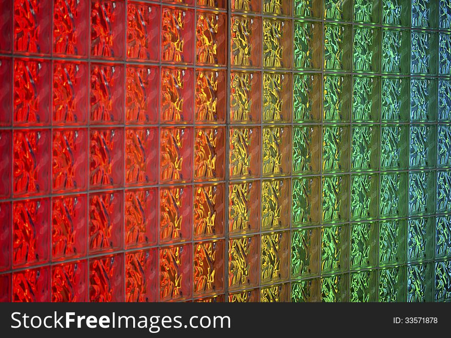Detail of glass block wall back-lit with neon lights in rainbow colors. Image shows detail of blocks and colors. Detail of glass block wall back-lit with neon lights in rainbow colors. Image shows detail of blocks and colors.