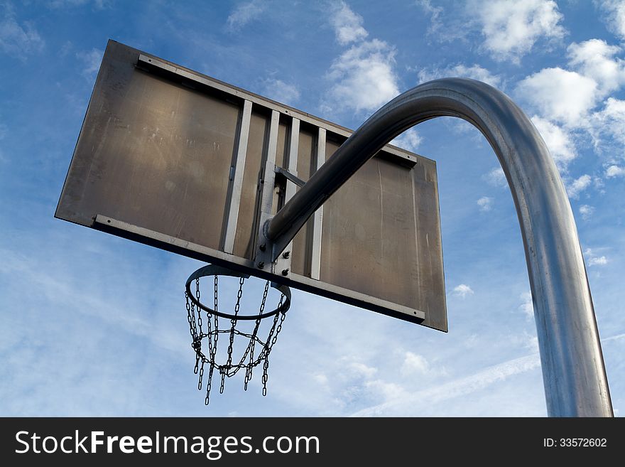 Basketball hoop from below with sky in the backdrop