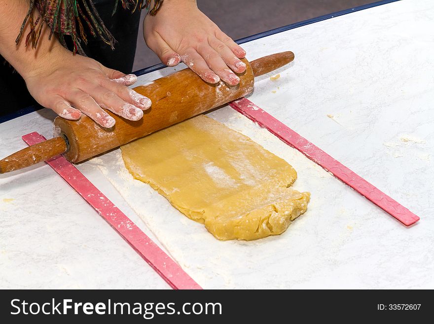 Child rolling dough on a table. Child rolling dough on a table