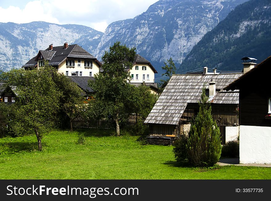Traditional wooden houses in Hallstatton the background of the alps