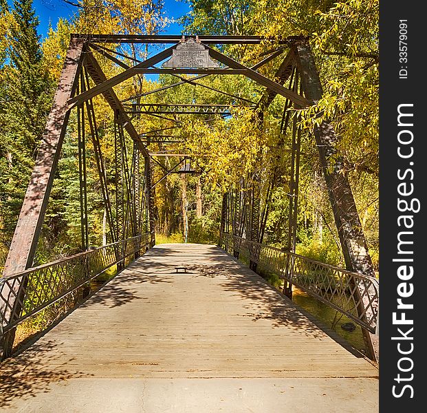 Old bridge surrounded by autumn trees in Colorado