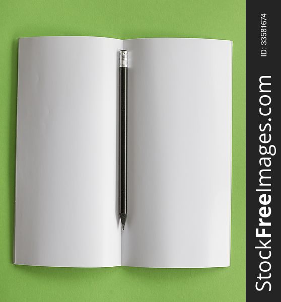 Top view of open blank notepad with pencil