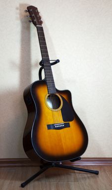 Six-string Acoustic Guitar On A Stand Stock Photo Six-string Acoustic Guitar On A Stand Stock Photo