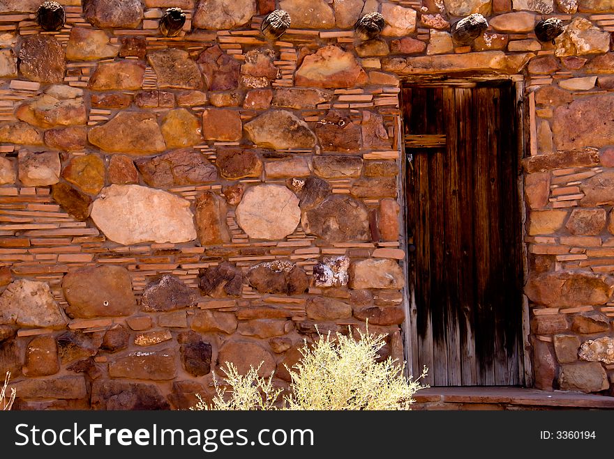 Wooden door in an old stone shack can be used as a background