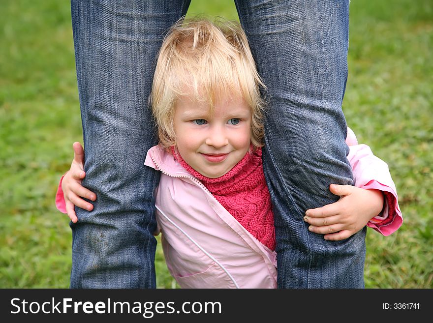 Daughter stands and he is held for the legs in jeans