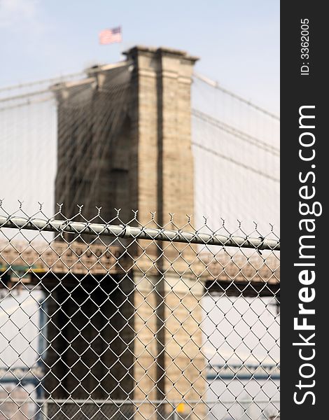 Barbed wire fence with brooklyn bridge in background