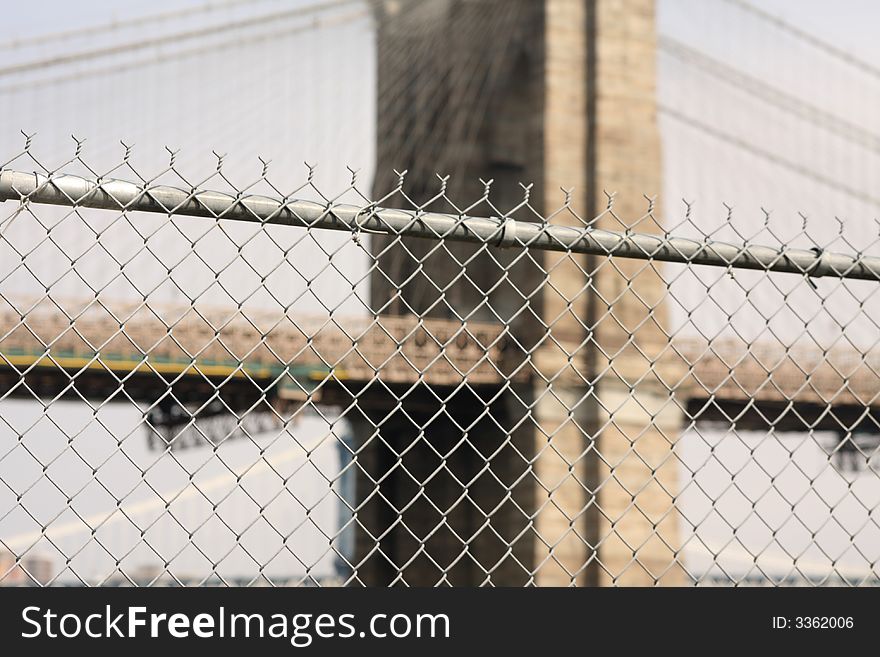 Barbed wire fence with brooklyn bridge in background