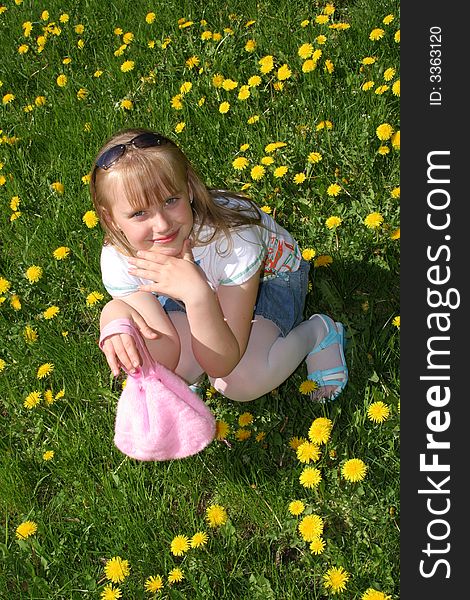 Young girl on the glade with dandelions