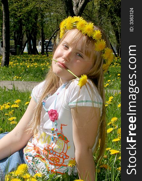 Young girl on the glade with dandelions