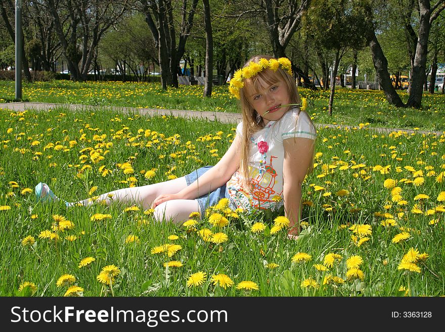 Young girl on the glade with dandelions