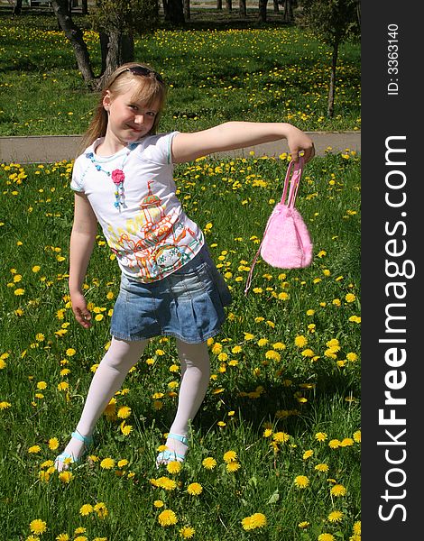 Young girl on the glade with dandelions. Young girl on the glade with dandelions