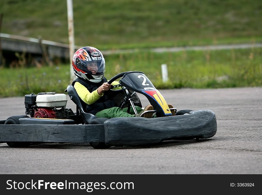 Girl with crash-helmet and driving karting. Girl with crash-helmet and driving karting.