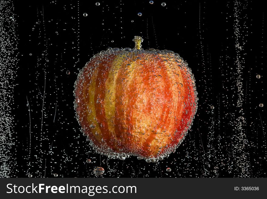 Fresh, clean apple in clear, bubbly liquid on a black background. Fresh, clean apple in clear, bubbly liquid on a black background.