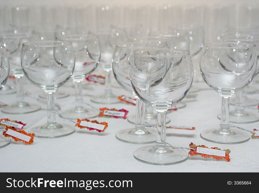 Rows of water glasses with name tags, on a linen tablecloth. Rows of water glasses with name tags, on a linen tablecloth