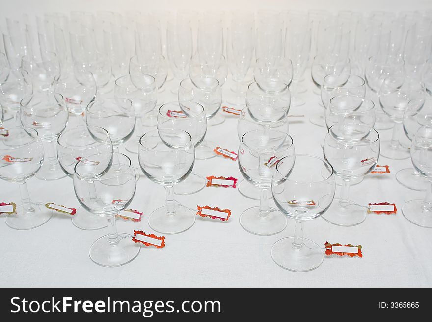 Rows of water glasses with name tags, on a linen tablecloth. Rows of water glasses with name tags, on a linen tablecloth