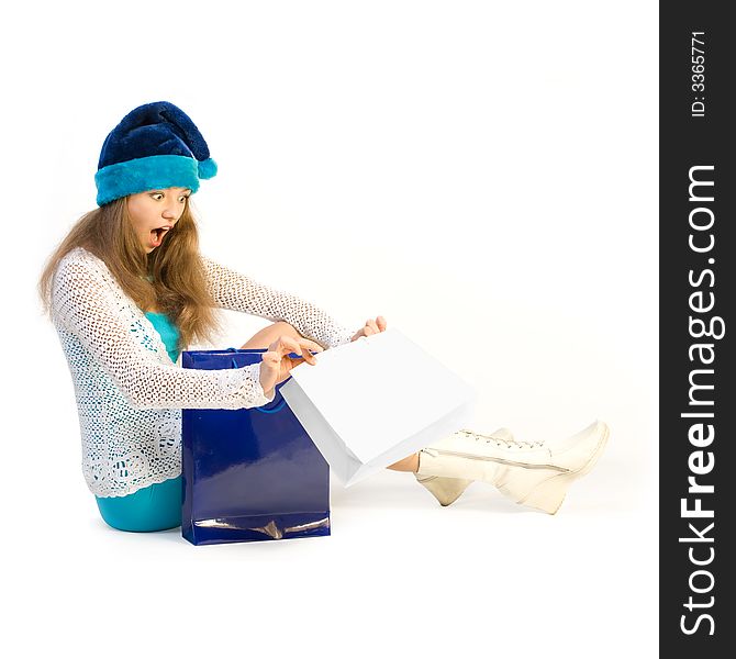 girl with delight looks in shoppingbag over white. girl with delight looks in shoppingbag over white