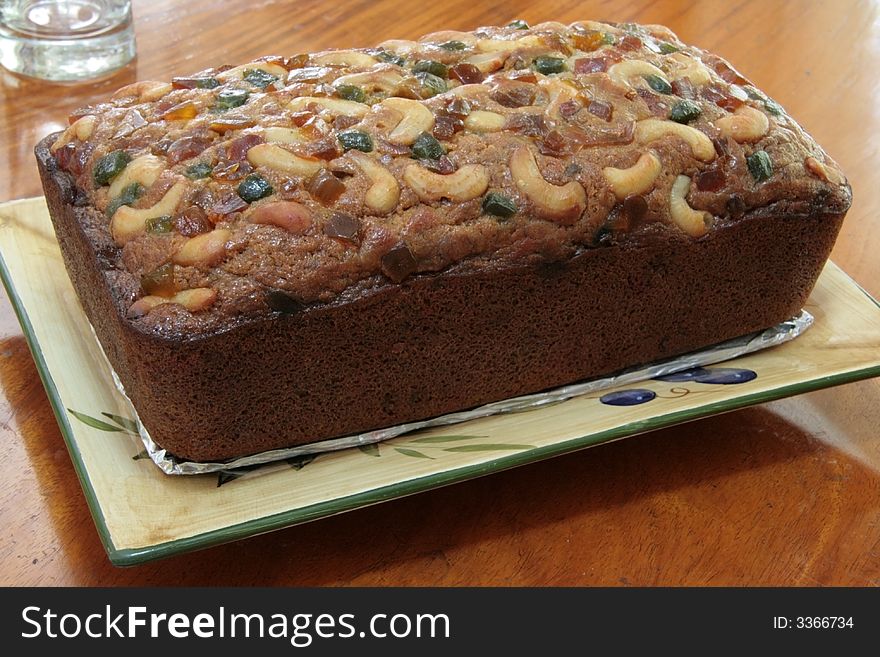 Banana bread loaf topped with glazed fruit and nuts