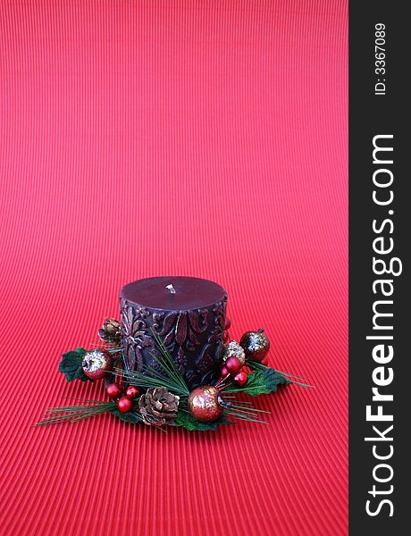 Dark pattern candle with a wreath on a red background. Dark pattern candle with a wreath on a red background