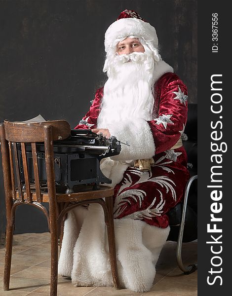 Santa Claus typing a letter on an typewriter. Santa Claus typing a letter on an typewriter