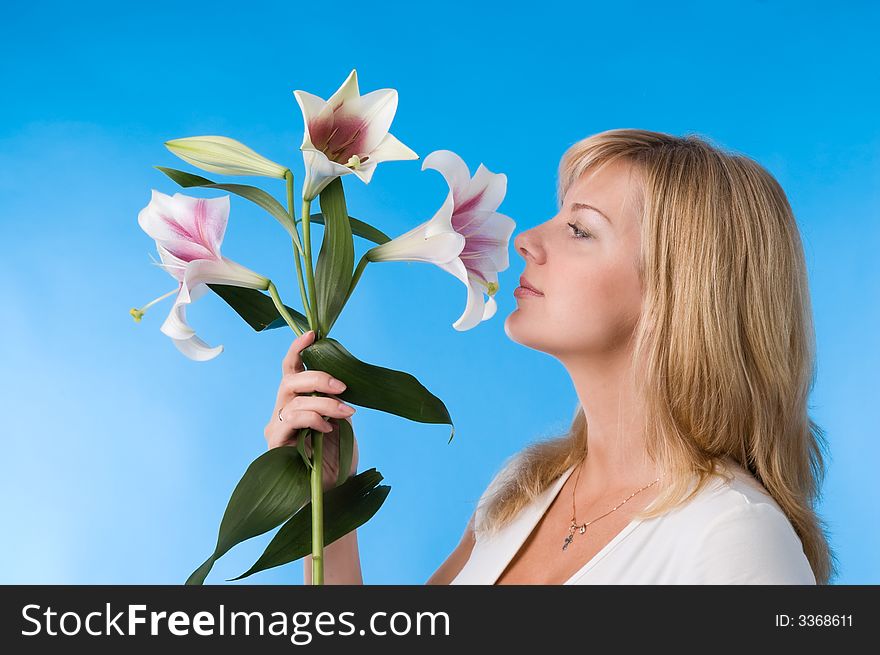 The attractive woman holds a liliy in hands. The attractive woman holds a liliy in hands