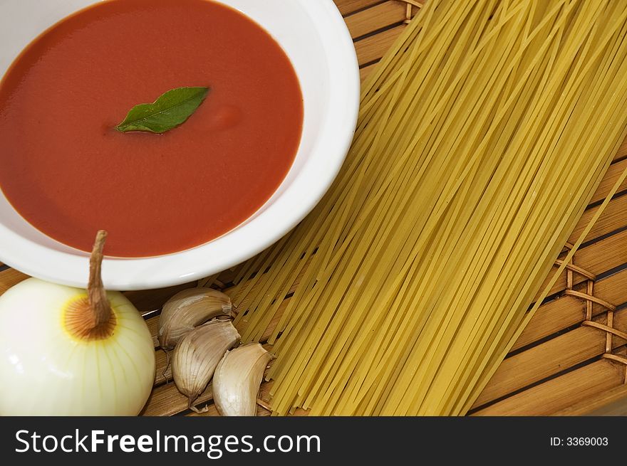 Spaghetti, tomato sauce, garlic and basil leaves on wood background. Spaghetti, tomato sauce, garlic and basil leaves on wood background