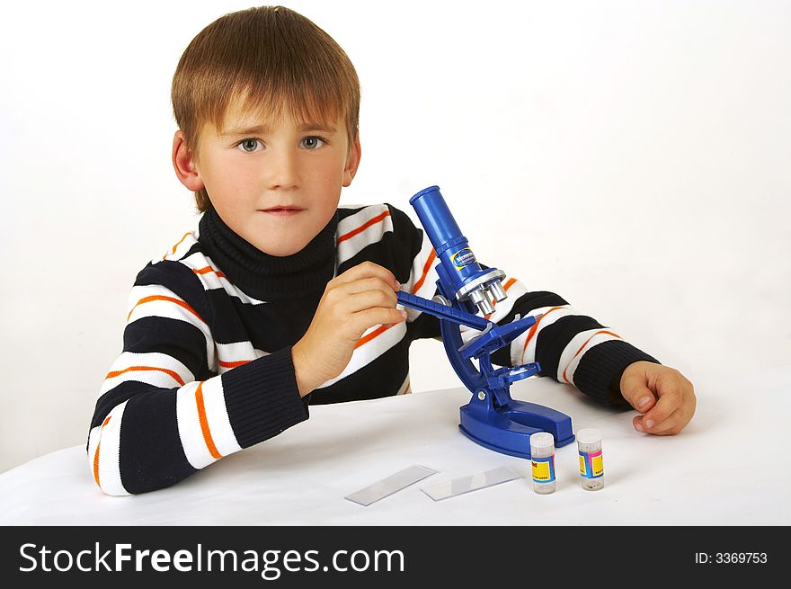 The boy with a microscope on a white background