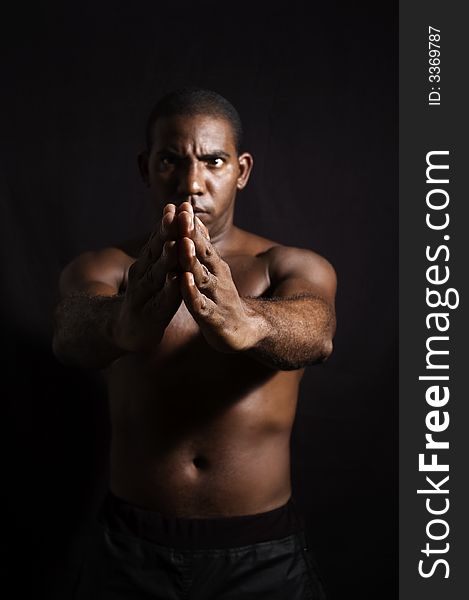 Portrait of young shirtless afroamerican male practising martial arts - isolated over black background. Portrait of young shirtless afroamerican male practising martial arts - isolated over black background