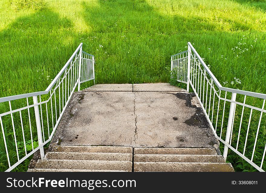 Old concrete staircase descends into the fresh grass. Old concrete staircase descends into the fresh grass