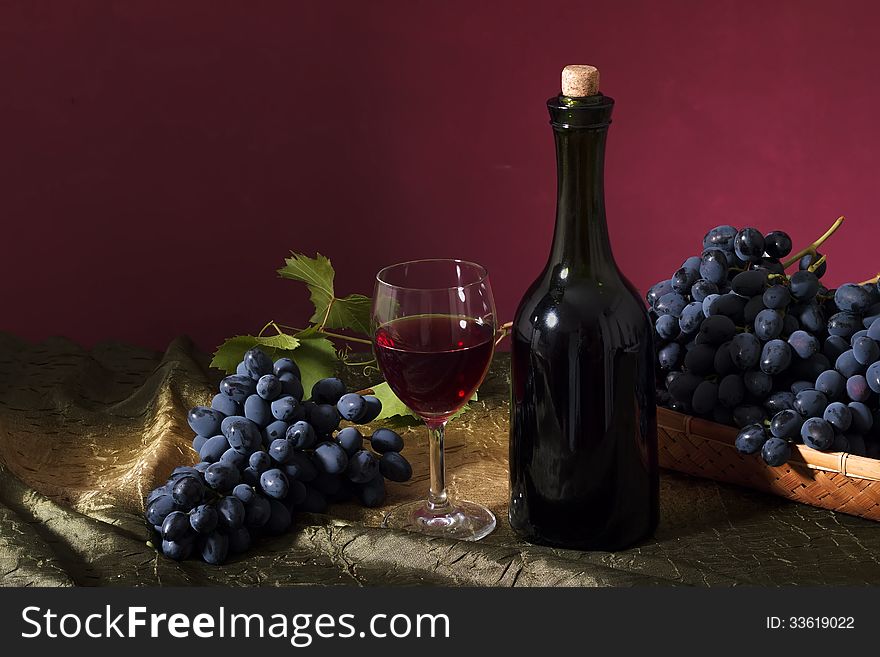 Still life with clusters of dark grapes and wine