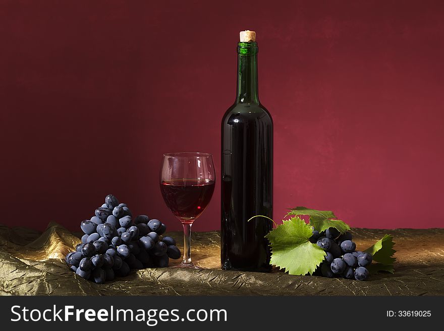 Still life with clusters of dark grapes and wine