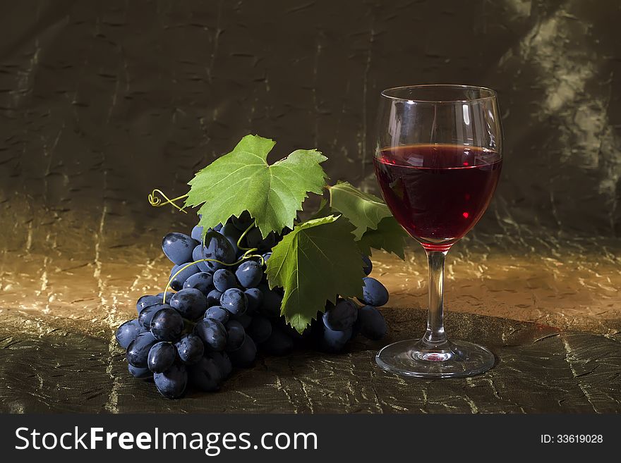 Still life with clusters of dark grapes and wine