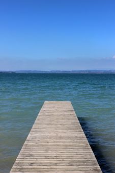 Wooden Jetty Going Out Into A Blue Lake. Royalty Free Stock Photos