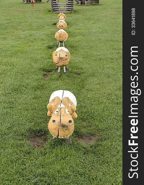 Sheep of wood, on a grass in a park playground.