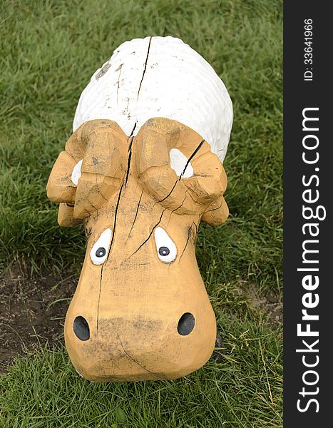 Sheep of wood, on a grass in a park playground.