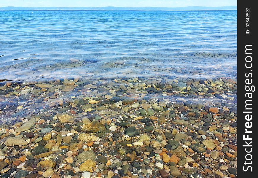 Horizontal photo of a clean, clear and transparent sea water. Pebbles and stones are visible in the sea. Horizontal photo of a clean, clear and transparent sea water. Pebbles and stones are visible in the sea.