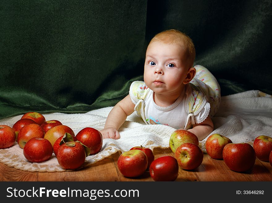 Redhead babe lying among ripe apple and smiling at the camera. Redhead babe lying among ripe apple and smiling at the camera