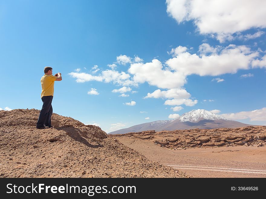 Man taking pictures of snowy mountain at Bolivian altiplano. Man taking pictures of snowy mountain at Bolivian altiplano