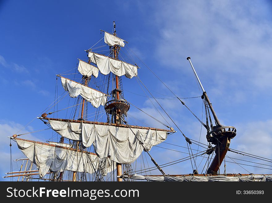 Yacht mast with sails against the sky