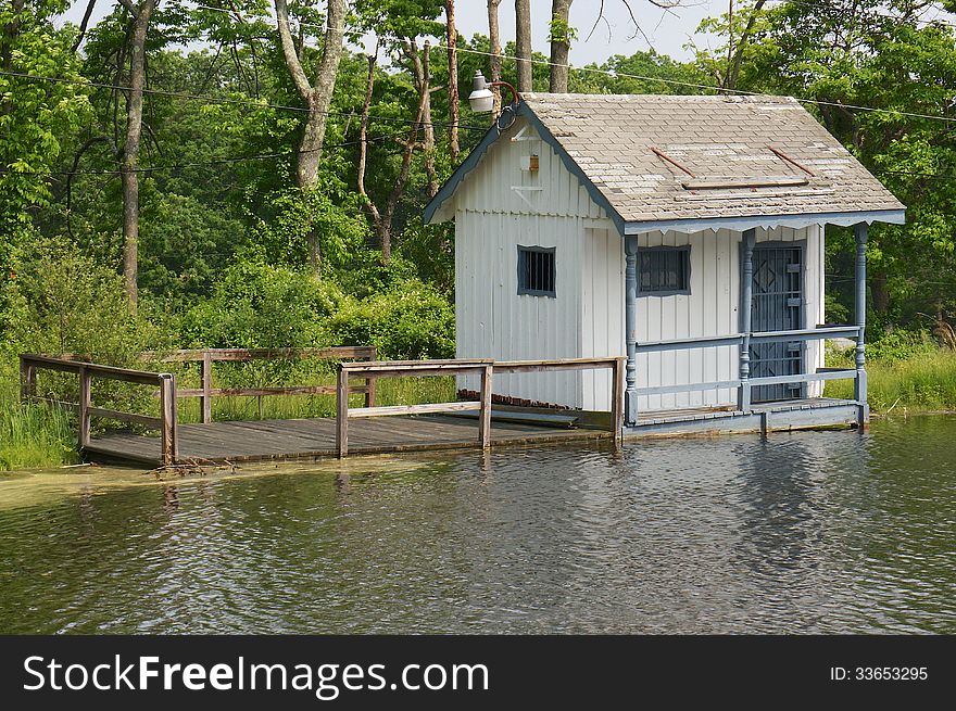 A unique small cottage sits on a floating dock on the shore of a Pennsylvania mountain lake. A unique small cottage sits on a floating dock on the shore of a Pennsylvania mountain lake.