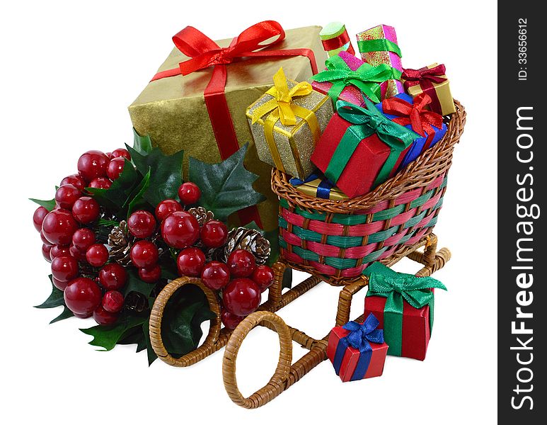 Toy Santas sledges with colorful gift boxes and bunch of berries isolated. Toy Santas sledges with colorful gift boxes and bunch of berries isolated