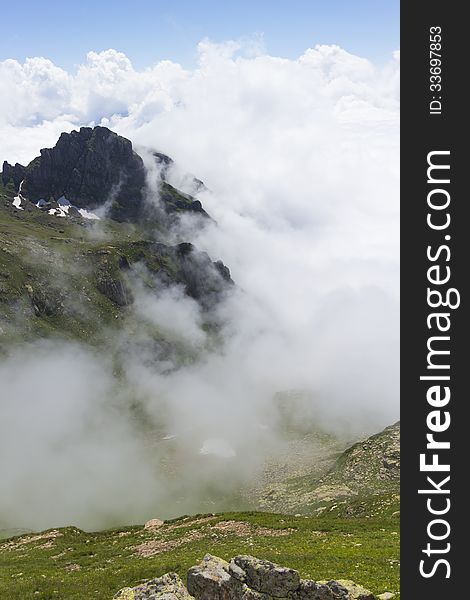 Landscape with high mountains, blue sky and clouds