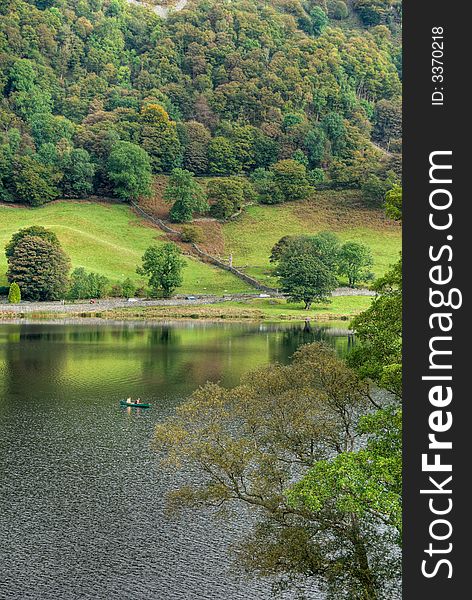 Two people canoeing on Rydal Water in the English Lake District under an overcast sky