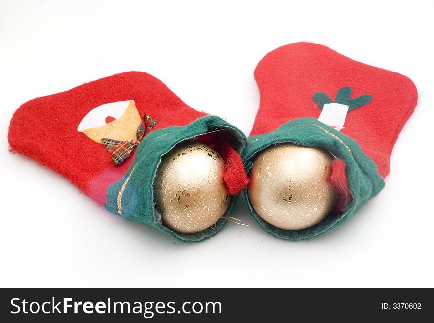 Photograph of Christmas stocking on white background with golden bulb.