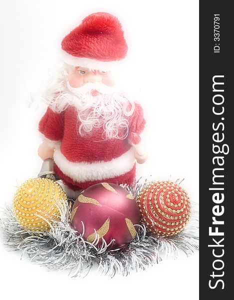 Santa Claus toy on white background with Christmas tree decorations.